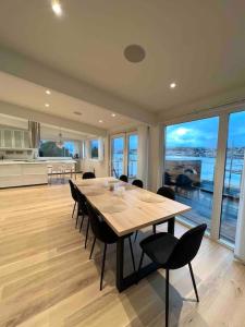 a dining room with a table and chairs and a kitchen at Fantastisk utsikt, nært sentrum in Tromsø