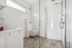 a bathroom with a toilet and a glass shower at Fantastisk utsikt, nært sentrum in Tromsø +20 photos