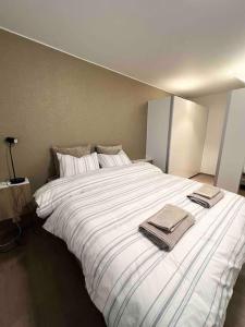 a large white bed with two towels on it at Fantastisk utsikt, nært sentrum in Tromsø