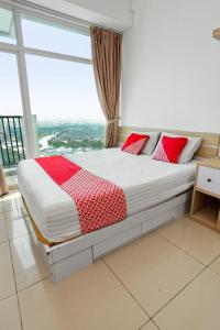 uma cama com almofadas vermelhas num quarto com uma janela em OYO 93432 Tree Room Hotel em Kebonnanas