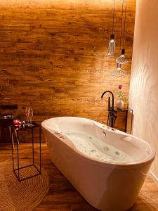 e bagno con vasca e parete in legno. di Golden Key Apartments a Liberec