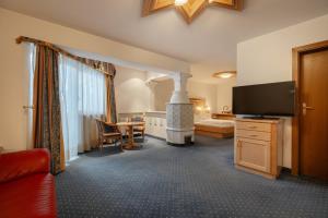 ein Hotelzimmer mit einem Bett und einem TV in der Unterkunft Piccolo Hotel in Wolkenstein in Gröden