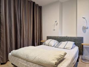 a bedroom with a large bed with a gray curtain at Appartement cœur de Doutre in Angers