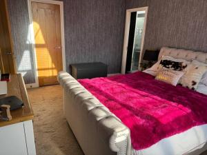 a bedroom with a large bed with a pink blanket at Izzy's house in Deysbrook