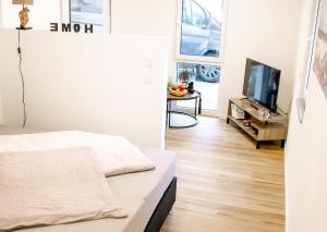 uma sala de estar com uma cama e uma televisão em AD1716 Apartments em Marktheidenfeld