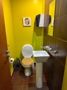 a yellow bathroom with a toilet and a sink at Aparta Hotel in Buenos Aires