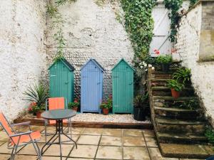 um pátio com portas azuis e uma mesa e cadeiras em Seaside Flat With Sunny Garden. em Brighton & Hove