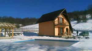 een klein huisje in de sneeuw naast een tuin bij Vikendica Cican Jahorina in Jahorina