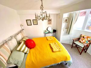Un dormitorio con una cama con una manta amarilla encima. en Seaside Flat With Sunny Garden., en Brighton & Hove