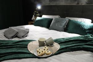 a tray of donuts and a cup of coffee on a bed at Hellene Snow Starý Smokovec in Vysoke Tatry - Stary Smokovec