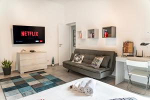 a living room with a couch and a tv on the wall at La casa del Conte in Messina