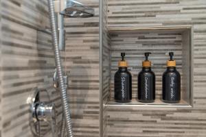 three black bottles sitting on a shelf in a bathroom at La casa del Conte in Messina +23 photos