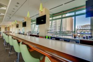 a bar with a long counter with green chairs at Emerald Beach by Panhandle Getaways in Panama City Beach