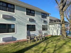 two chairs sitting in the grass in front of a house at Harbor Winds Hotel in Sheboygan