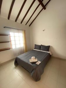 a bedroom with a large bed with a window at Hostal Villa Carmen in Villa de Leyva