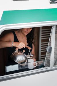 a woman holding a tea pot in a car window at Pénichettes itinérantes sans permis - Locaboat in Lattes