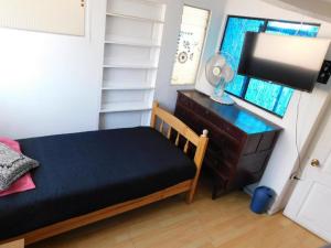 1 dormitorio con 1 cama, vestidor y TV en Hostal Pampaloja, en Antofagasta