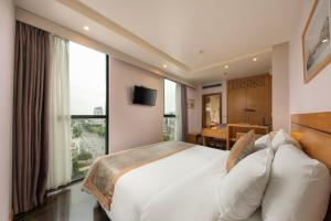 sypialnia z dużym białym łóżkiem i dużym oknem w obiekcie Parkside Sunline Hotel w mieście Hanoi