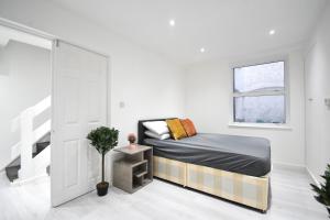 Habitación blanca con cama y ventana en Superb Garden Apartment en Londres