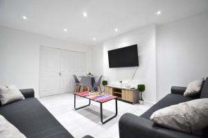 un soggiorno con 2 divani e una TV di Superb Garden Apartment a Londra