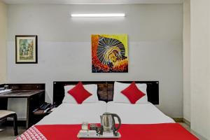 1 dormitorio con 1 cama grande con manta roja en Super OYO Flagship Hotel Diva Inn en Nagpur
