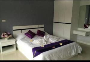 a bedroom with a large bed with purple pillows at Pandora House by Mike Group in Pattaya North