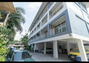 a large white building with cars parked in front of it at Pandora House by Mike Group in Pattaya North