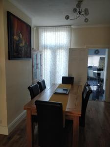 a dining room with a wooden table and chairs at Whites Place in Slades Green