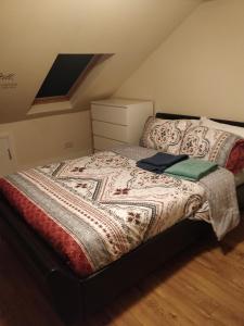 a bed with a quilt on it in a bedroom at Whites Place in Slades Green