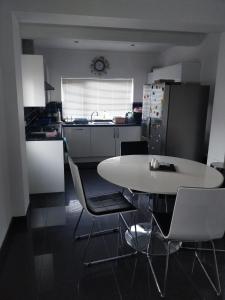 a kitchen with a white table and chairs at Whites Place in Slades Green