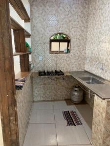 una pequeña cocina con fregadero y ventana en Casa Mobiliada em Arraial (20 metros do CÁS, onde saem os passeios de barco), en Arraial do Cabo