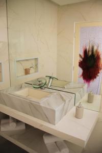 a white bathroom with a tub and a mirror at Villa Maria Bonita in Pipa