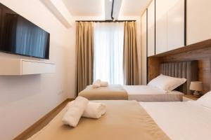um quarto de hotel com duas camas e uma televisão de ecrã plano em Villa Florale em Široka