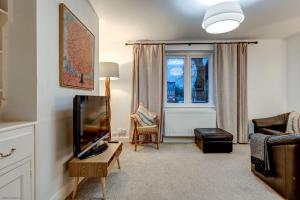 a living room with a tv and a couch at The Oxford Meadows in Oxford