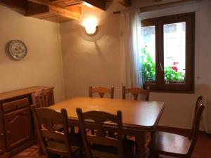 d'une salle à manger avec une table, des chaises et une fenêtre. dans l'établissement Habitatge familiar de Can Bota Batllo, à Setcases