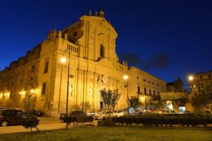 een groot gebouw waar 's nachts auto's voor geparkeerd staan bij Real Umberto I° Suite - Kalsa in Palermo
