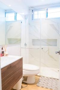 uma casa de banho com um WC e uma cabina de duche em vidro. em Luxury Apartment Toscana style, brand new em Guayaquil