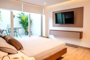 a bedroom with a large bed and a flat screen tv at Luxury Apartment Toscana style, brand new in Guayaquil
