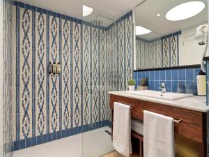 a bathroom with blue tiled walls and a sink at H10 Suites Lanzarote Gardens in Costa Teguise