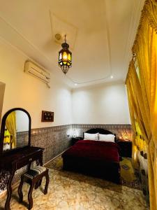 a bedroom with a bed and a mirror and a chandelier at Dar Al Fassia in Oujda