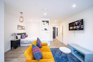a living room with a yellow couch and a bed at Prime Serviced Apartments Sheffield Center in Sheffield