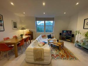 a living room with a white couch and a table at Beautiful 3 Bed in Leafy Hampstead in London