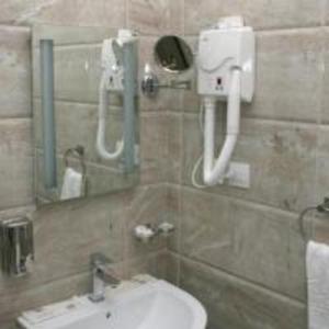 baño con lavabo y teléfono en la pared en 7 Wonders Hotel, en Wadi Musa