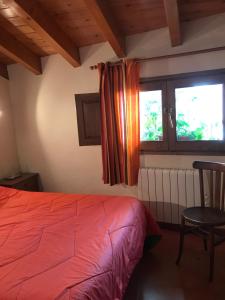- une chambre avec un lit, une fenêtre et une chaise dans l'établissement Habitatge familiar de Can Bota Batllo, à Setcases