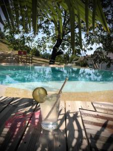 una bebida sentada en una mesa junto a una piscina en La Marc'quize, en Mouxy