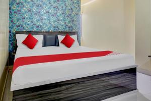 Flagship Sk Brother Hotel في باتنا: سرير مع وسائد حمراء وزرقاء في الغرفة