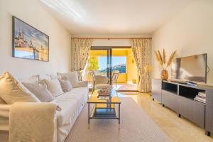 sala de estar con sofá blanco y TV en 7 Apartment near Duquesa Port Manilva Coto Real en Manilva