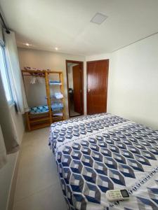 1 dormitorio con 1 cama con edredón azul y blanco en Flat Beira Mar Porto Segur en Porto Seguro