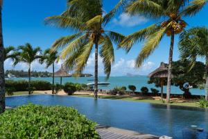 una piscina con palmeras y el océano en THE BAY 3 *****, en Grand Baie