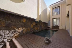 un perro tirado en una terraza junto a una piscina en THE BAY 3 *****, en Grand Baie 47 fotos más